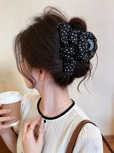 Close-up of a stylish Korean black floral fabric hair claw clip worn in an elegant updo