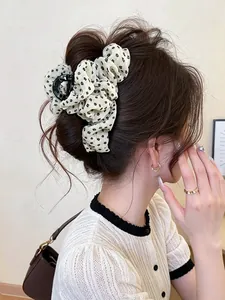 Elegant close-up view of vintage floral fabric hair claw clip on messy updo hairstyle