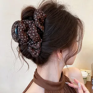 Detailed view of a brown checkered fabric-covered hair claw clip in an elegant updo