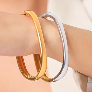 Nahaufnahme von minimalistischen quadratischen Armreifen aus Gold und Silberstahl