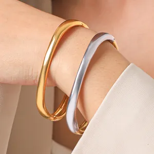Nahaufnahme von minimalistischen Gold- und Silberarmreifen aus Edelstahl mit Verschluss