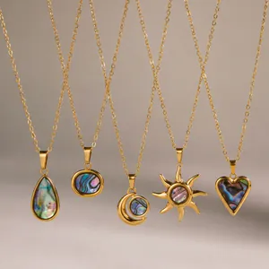 Gros plan de colliers en acier inoxydable doré avec des pendentifs en nacre de formes variées.
