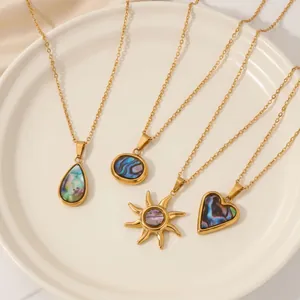 Vue détaillée de quatre colliers en acier doré avec des pendentifs en nacre d'abalone