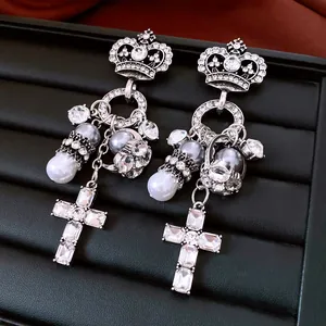 Detailansicht der verzierten silbernen Kronenohrringe mit Perlen und Kristallkreuz