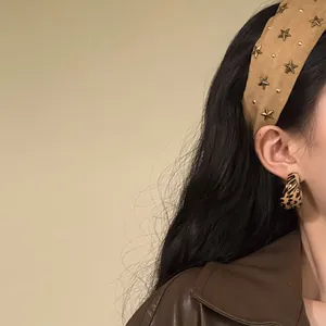 Detailopname van een retro kaki stoffen hoofdband met gouden sterren