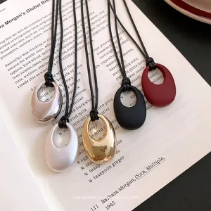 Minimalistisches koreanisches Set aus ovalen Anhängern mit schwarzer Lederkordel in Farben