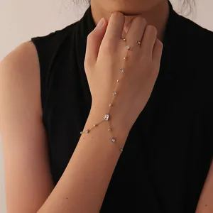 Detailed view of an elegant gold stainless steel hand chain decorated with white crystals