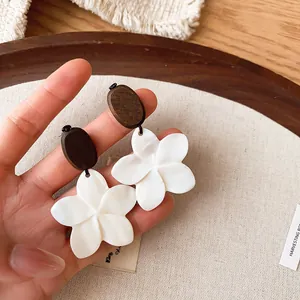 Close-up detail of vintage ethnic flower earrings with brown beads and shell-like finish