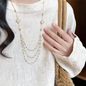 Detail of a layered gold-tone necklace featuring sparkling zircon-encrusted rhombus charms.
