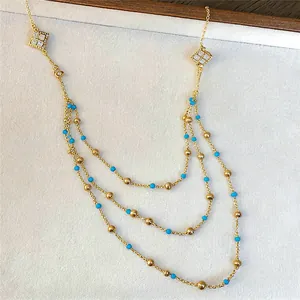 Detailed view of gold multi-layer necklace with turquoise beads and zircon diamonds