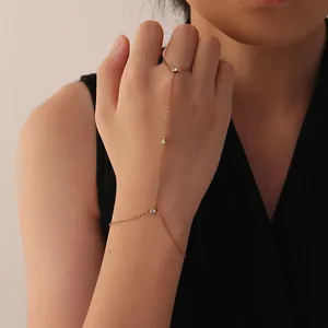Close-up of minimalist gold stainless steel hand harness bracelet with white stones