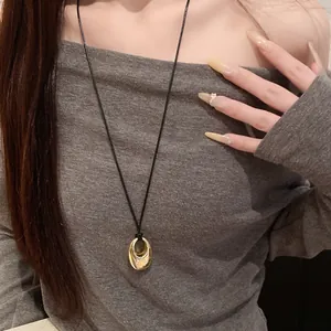 Nahaufnahme einer ovalen Anhängerkette im koreanischen Stil mit schwarzer Schnur.