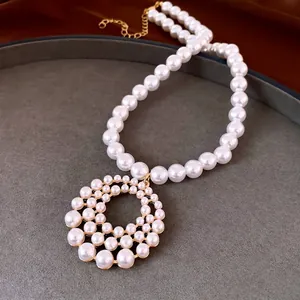 Elegante Perlenkette mit einem großen kreisförmigen hohlen Anhänger in Goldoptik