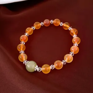 Élégant bracelet en perles d'agate orange avec accent de jade vert sur fond de soie
