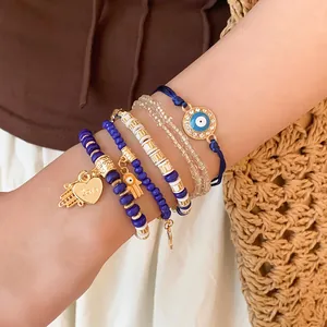 Ensemble de bracelets bohèmes en perles avec œil protecteur et breloque cœur au poignet.