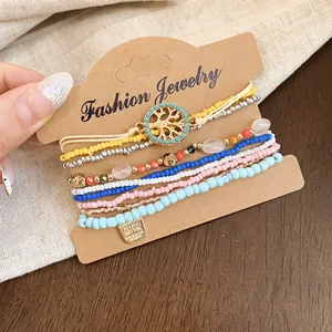 Détail d'un ensemble de bracelets en perles bohèmes avec charme arbre de vie coloré.
