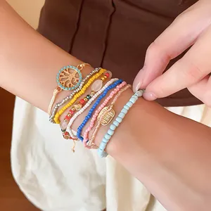 Vue détaillée d'un ensemble de bracelets en perles bohèmes avec breloques dorées et perles