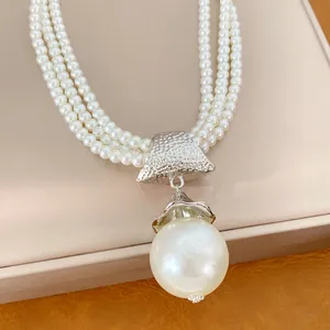 Detailansicht einer luxuriösen dreilagigen Perlenkette aus Acryl mit Barock-Anhänger