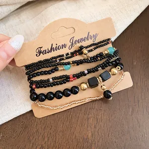 Gros plan d'un ensemble de bracelets bohèmes avec perles noires et dorées