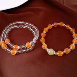 Gros plan de bracelets élégants en perles d'agate avec pierres transparentes et orange