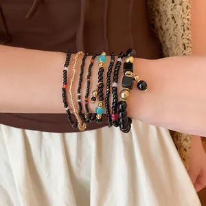 Ensemble de bracelets bohèmes multicouches avec perles dorées et touches de turquoise.