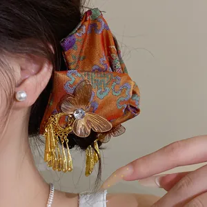 Nahaufnahme einer chinesischen Haarspange mit goldenem Schmetterling und Quasten.