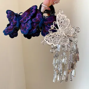 Detail einer Haarspange im Ethno-Stil mit Schmetterlingsstickerei und Silberquasten