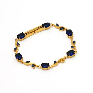 Vue détaillée d'un élégant bracelet tulipe doré serti de zircons ovales de couleur bleu.