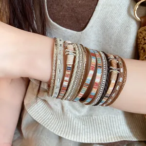 Gedetailleerd beeld van een meerlaagse boho lederen armband met glanzende strassteentjes om de pols