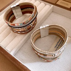 Close-up van bohemian meerlaagse lederen armbanden met strass-steentjes in een juwelendoos