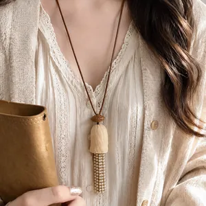 Gros plan d'un collier vintage de style chinois avec un gland en perles élégantes