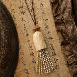 Détail macro d'un collier vintage de style chinois avec un élégant pompon en perles