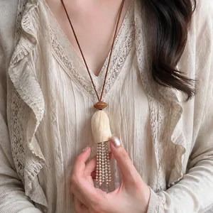 Détail du collier rétro de style chinois avec noyau de fruit et pampilles de perles