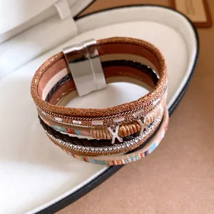 Detailopname van een bohemian meerlaagse lederen armband met stras en magneetsluiting