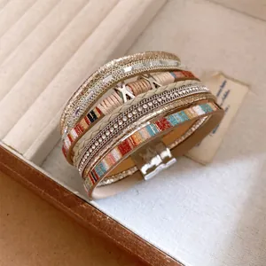 Detailweergave van een meerlaagse leren armband met magnetische sluiting en stras.