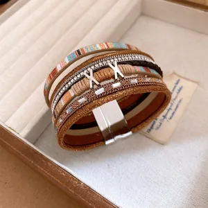 Detail van meerlaagse lederen armband met magnetische sluiting en strass-steentjes