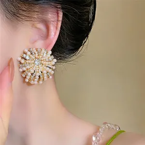 Boucles d'oreilles fleur vintage avec perles et strass brillants portées par un mannequin