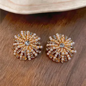 Boucles d'oreilles vintage en argent avec perles et strass sur fond en bois