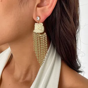 Vue détaillée de boucles d'oreilles lion danse en résine avec longues franges dorées