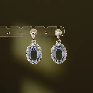 Detailweergave van elegante ovale blauwe zirkoon oorbellen met zilveren naald
