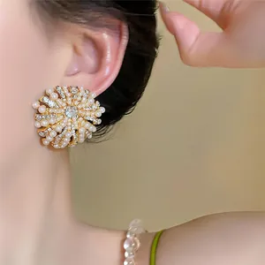 Détail rapproché de boucles d'oreilles fleurs vintage avec perles et strass brillants