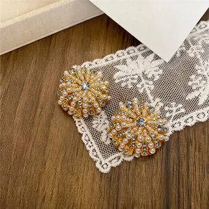 Détail de boucles d'oreilles fleur vintage de luxe avec perles et strass brillants