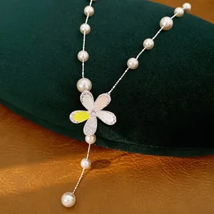 Süße Perlenkette mit glitzerndem Zirkonia-Blumenanhänger auf dunkelgrüner Samtbox