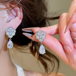 Detailaufnahme eleganter Zirkonia-Blumenohrringe mit einem birnenförmigen Kristall-Anhänger.