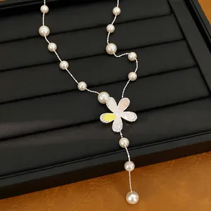 Detailansicht einer zierlichen Perlenkette mit funkelndem Zirkonia-Blumenanhänger
