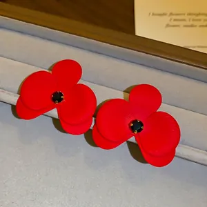 Elegante rote Blumenstecker mit schwarzem Mittelstein in einer Schmuckschatulle