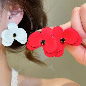 Detailansicht der matt lackierten Blumenohrstecker mit schwarzen Kristallen in Rot und Weiß