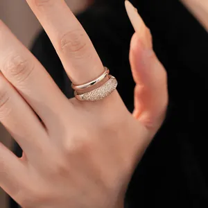 Vista detallada de un anillo de doble capa con un diseño de malla y circonitas.