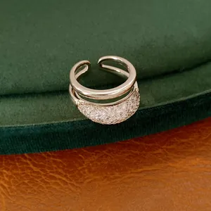 Primer plano de anillo abierto de doble capa con detalles de circonita y rejilla