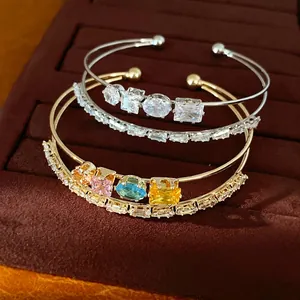 Eleganter 18k vergoldeter Doppel-Armreif mit bunten Zirkoniasteinen im offenen Design.